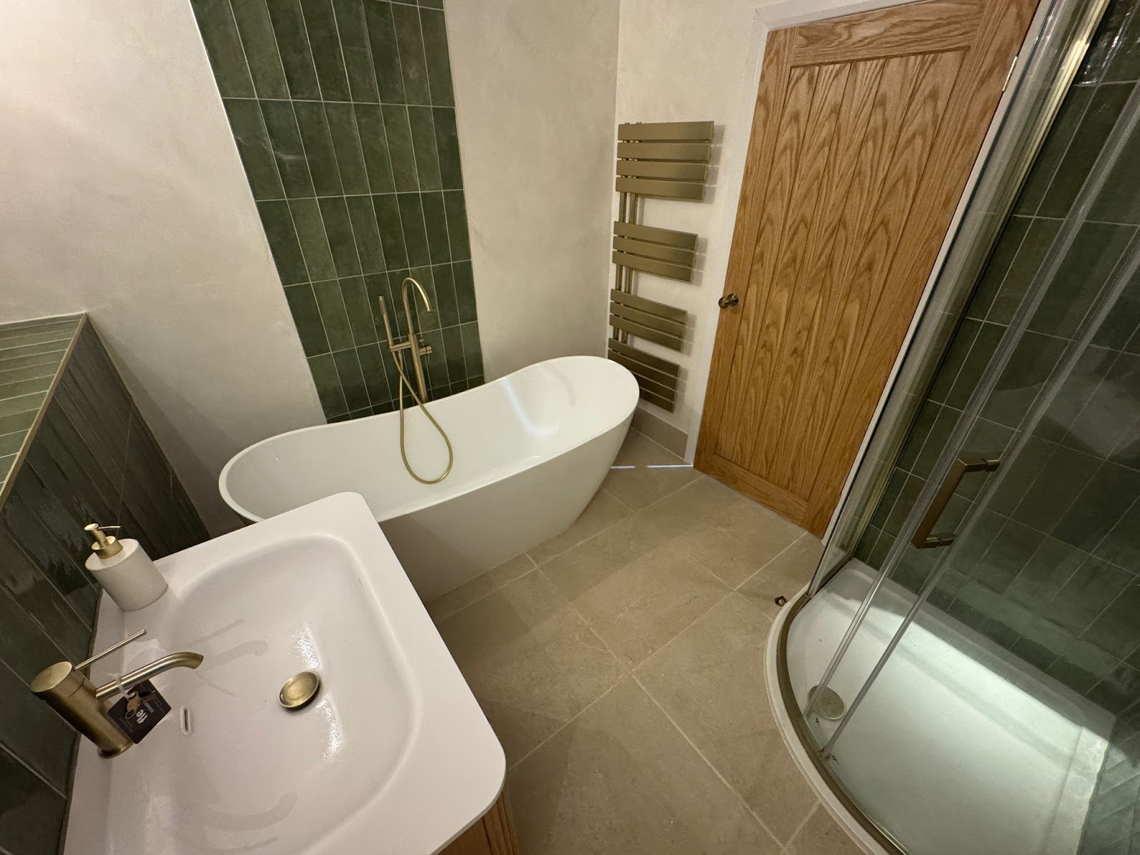 A full family bathroom — freestanding bath, corner shower enclosure and solid oak door.